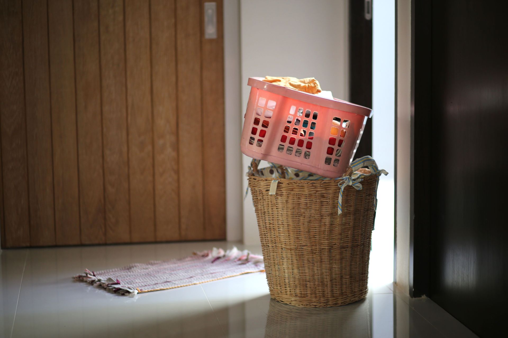 Two laundry baskets filled with clothes near a wooden interior door, hinting at household chores.